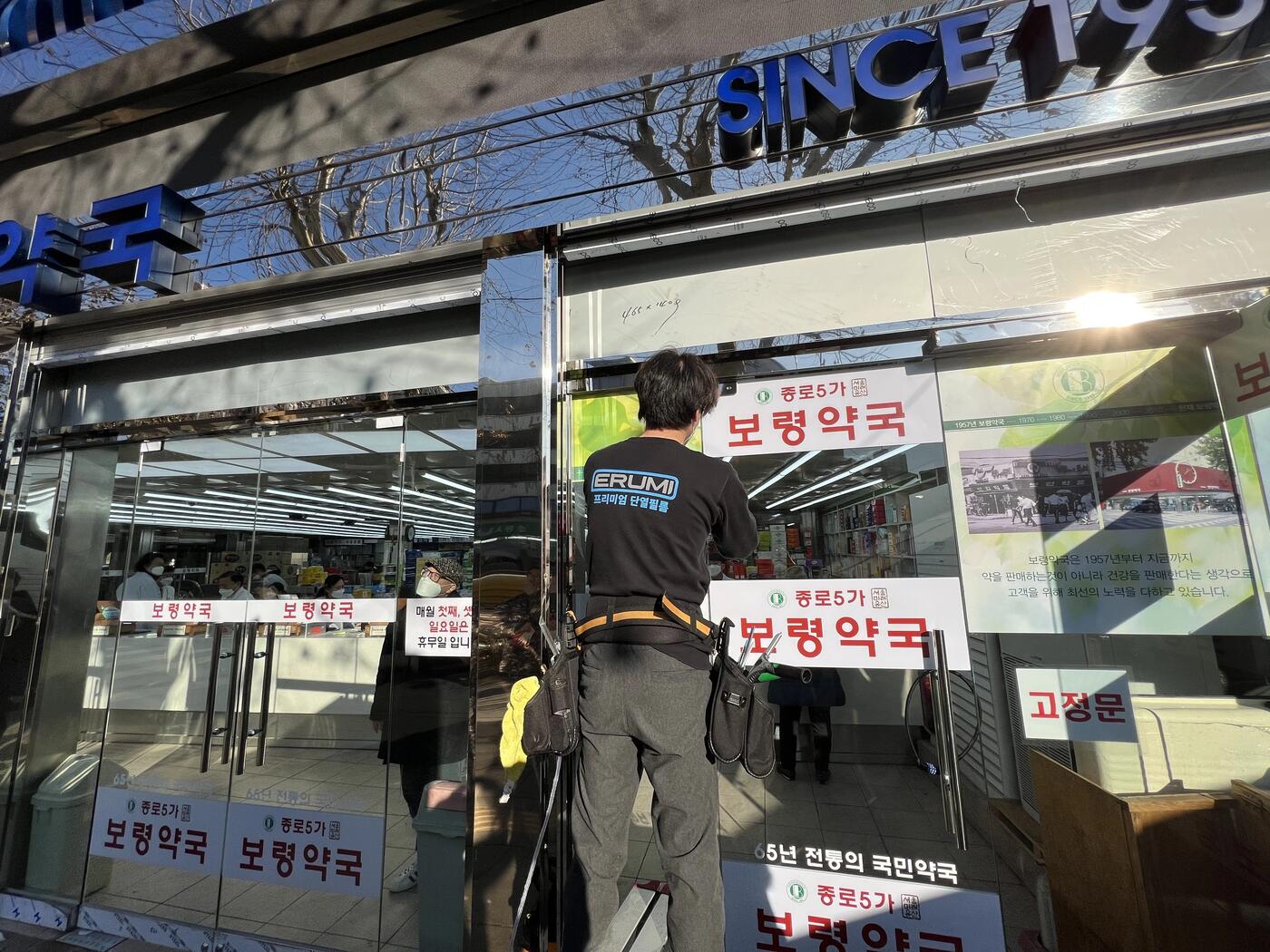 약국 자동문 유리 안내문 부착 유리문썬팅 시공 작업자 사진